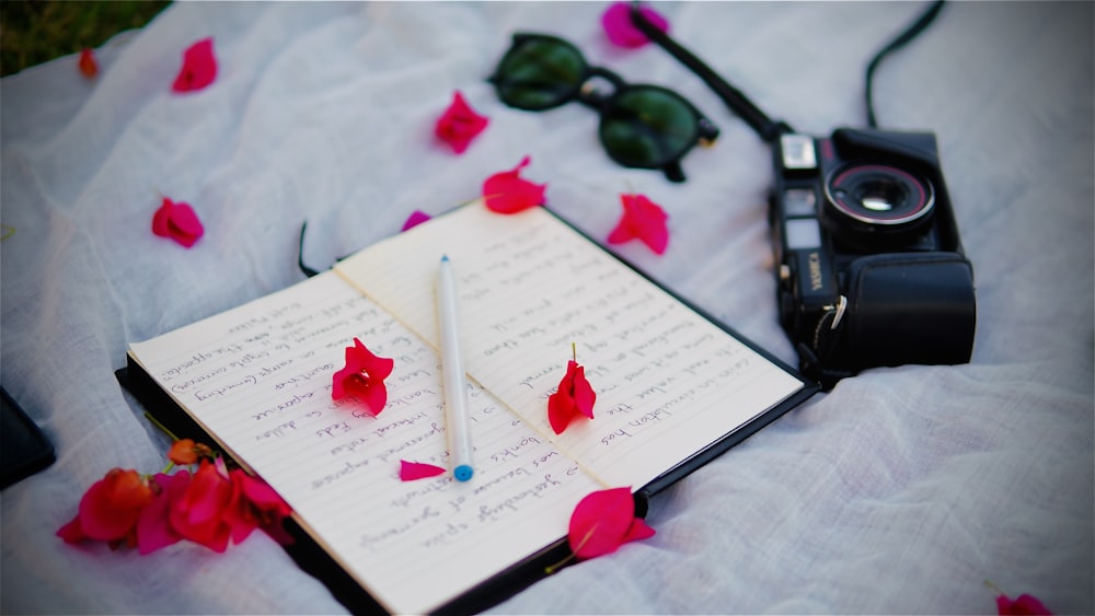 a book with a pen and some flowers on it