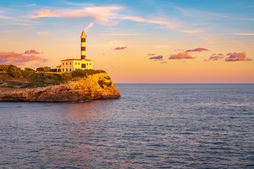 a lighthouse on a small island in the middle of the ocean