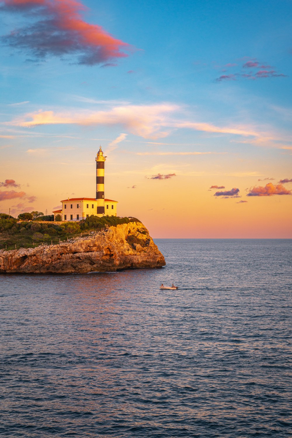 a lighthouse on a small island in the middle of the ocean