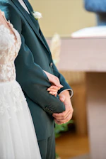 A close-up of a couple holding hands during a private anniversary celebration in a secluded garden.