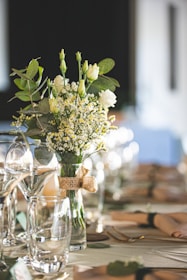 Elegant silver and natural flower bouquet arrangement on a rustic wooden table.