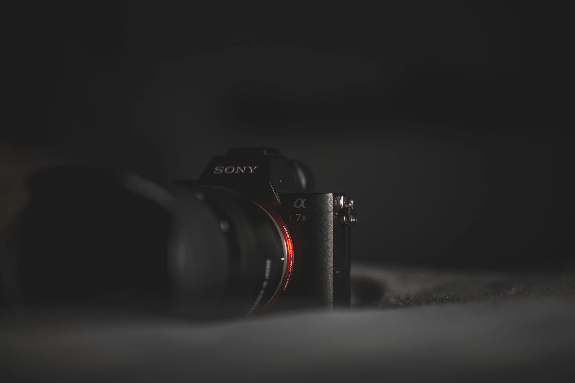 A Sony Alpha camera resting in low, quiet light