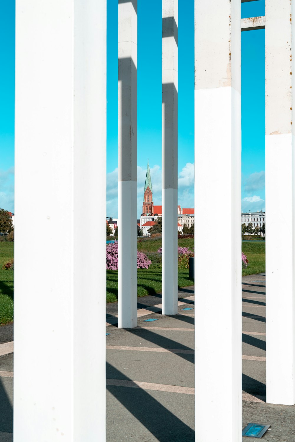 a group of white pillars with a clock tower in the background