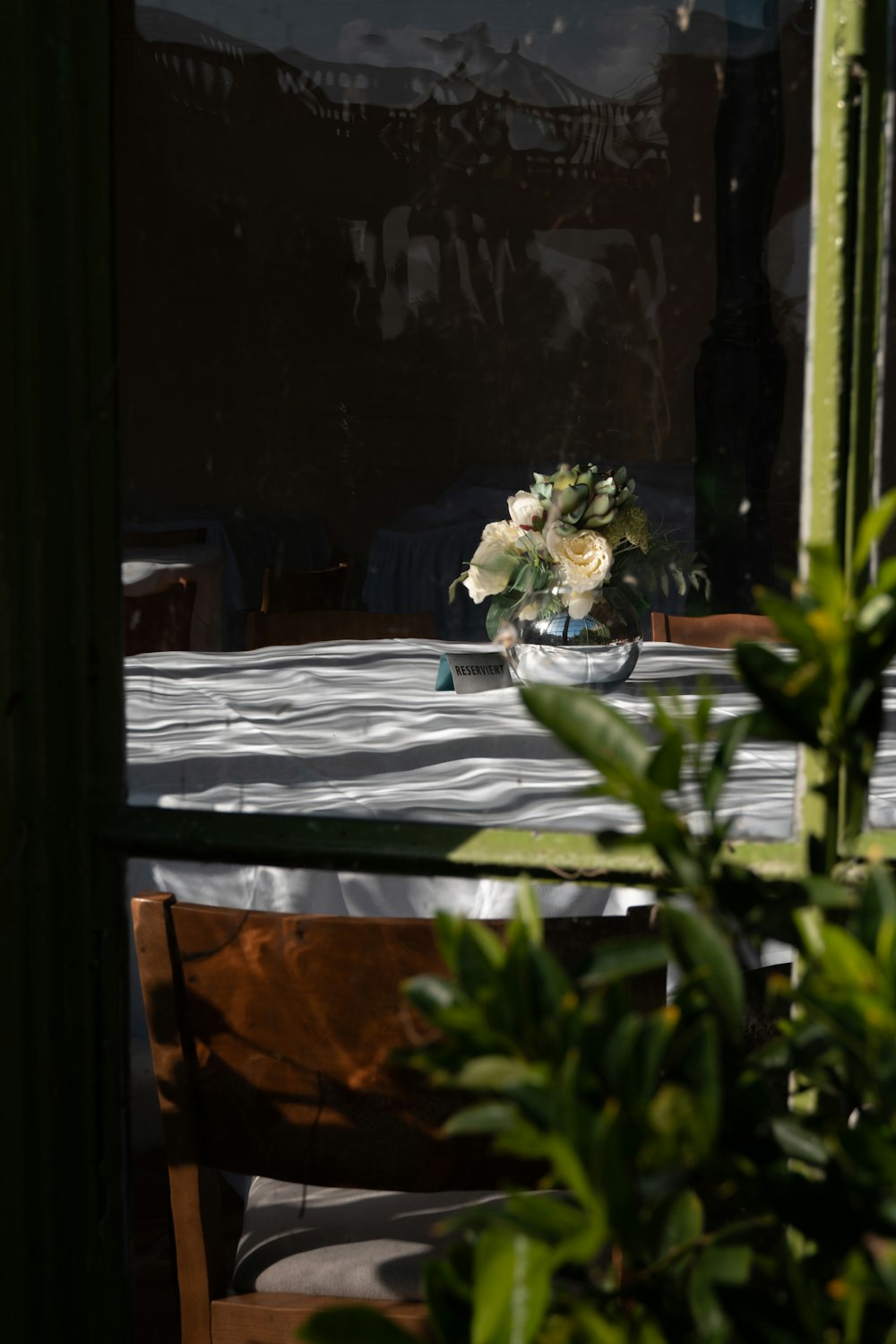 a vase of flowers sitting on a table in front of a window