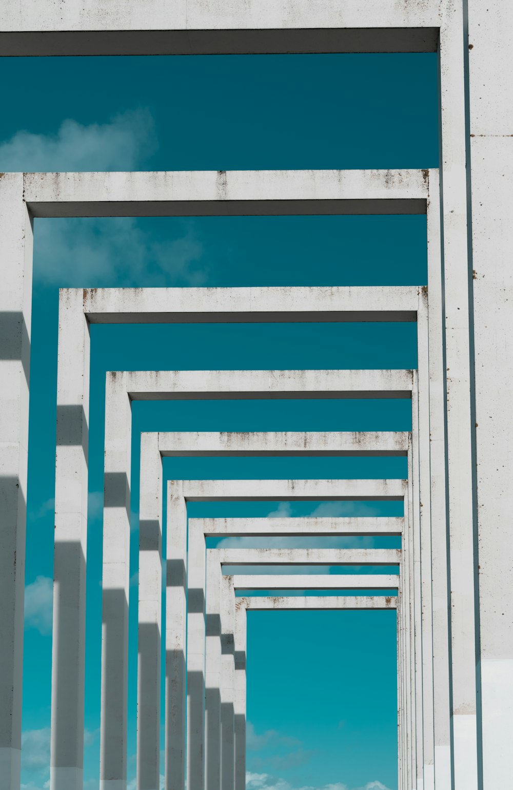 a row of white pillars against a blue sky