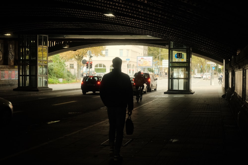 a man walking down a sidewalk at night