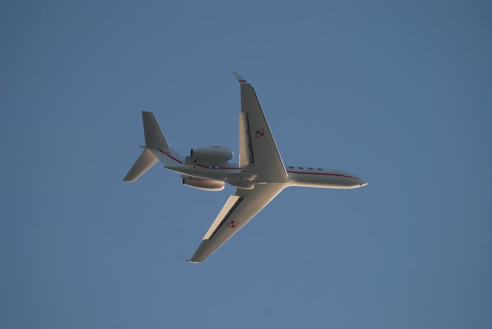 a plane flying in the sky with its landing gear down