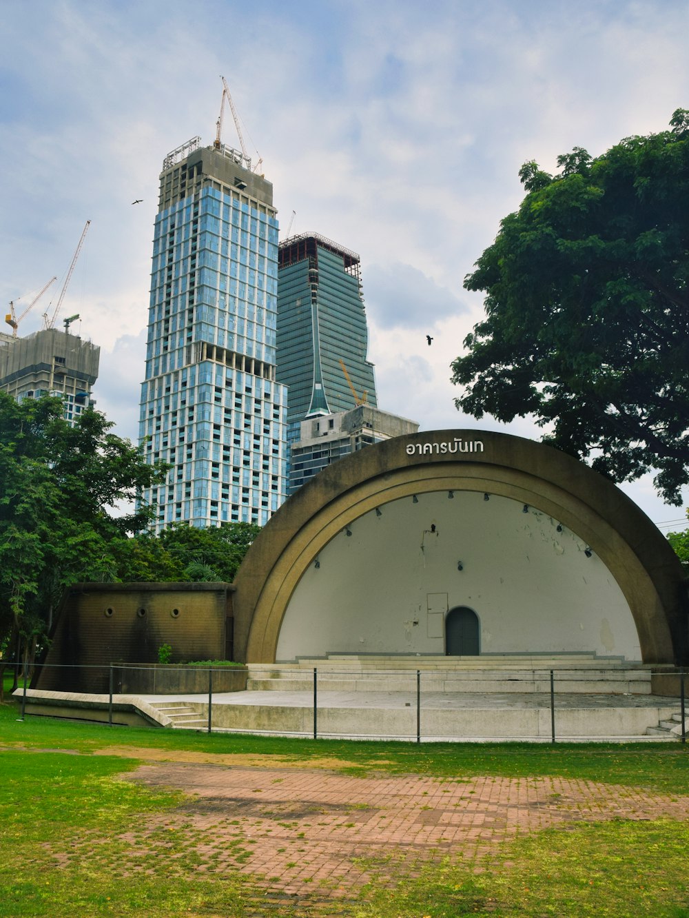 a large white building sitting next to a lush green park