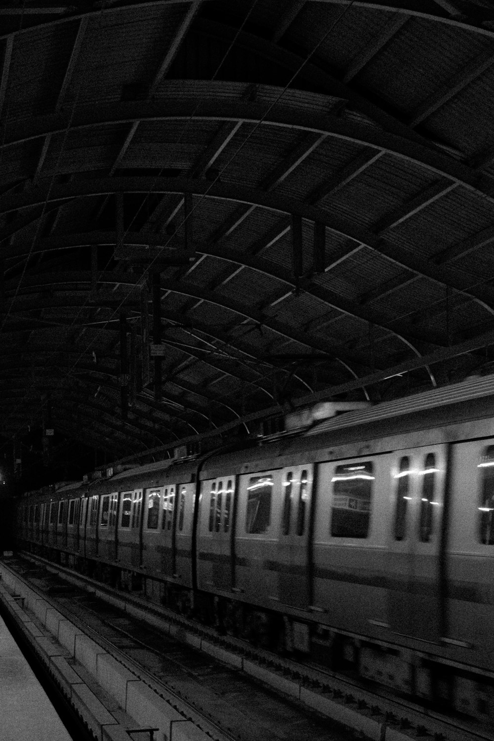 une photo en noir et blanc d’un train dans une gare