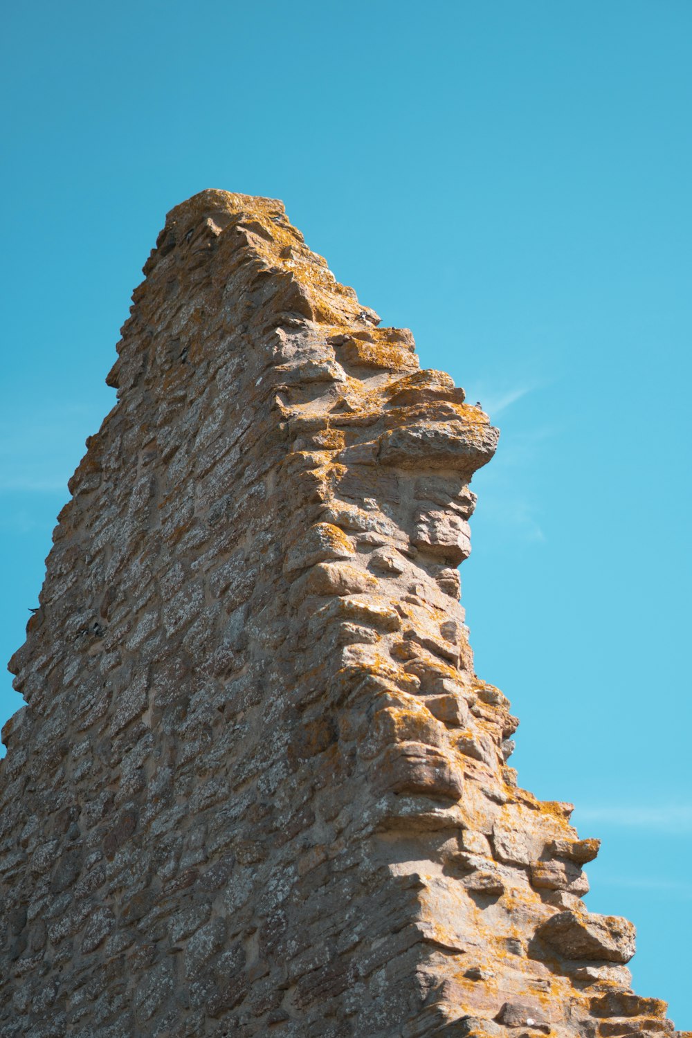 a stone tower with a bird perched on top of it