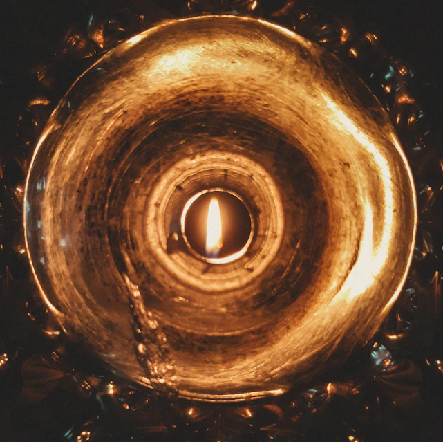 A warm, intimate close-up of a softly glowing flame symbolizing inner transformation and truth.