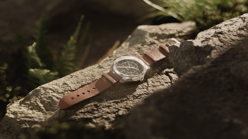 a watch sitting on top of a rock