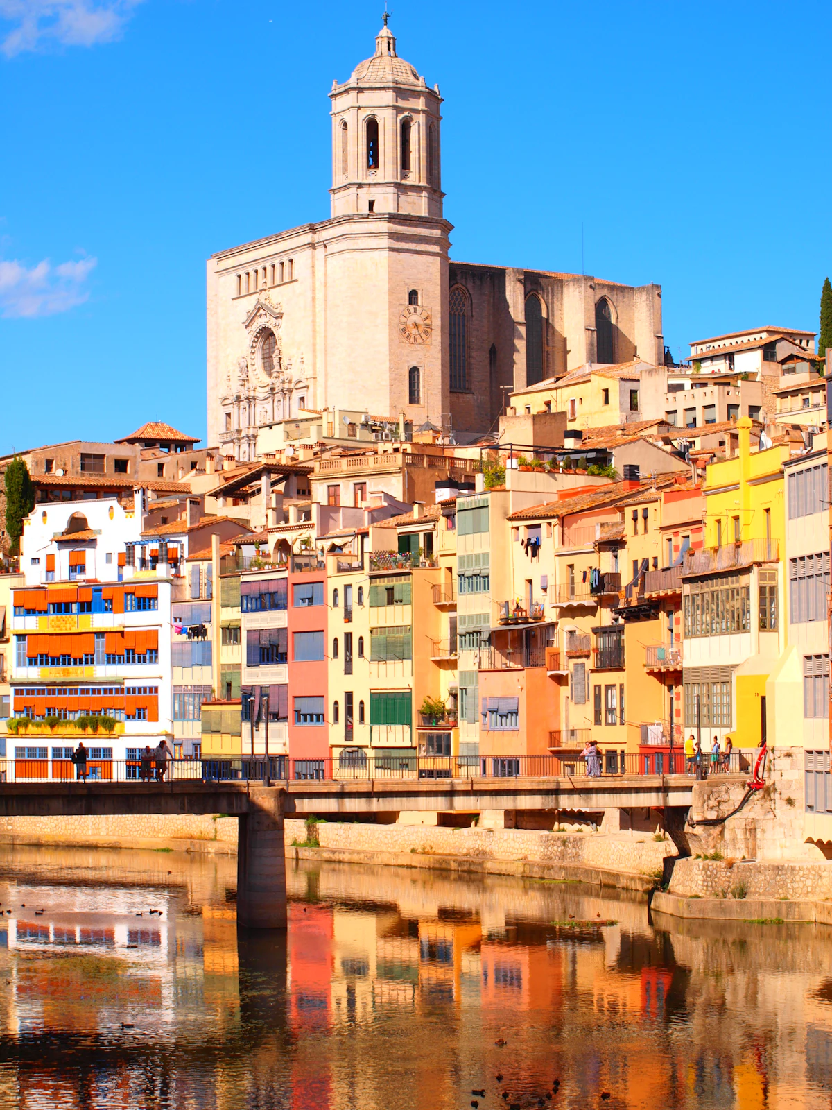 Girona's cathedral above the painted riverside houses, reflected in the Onyar