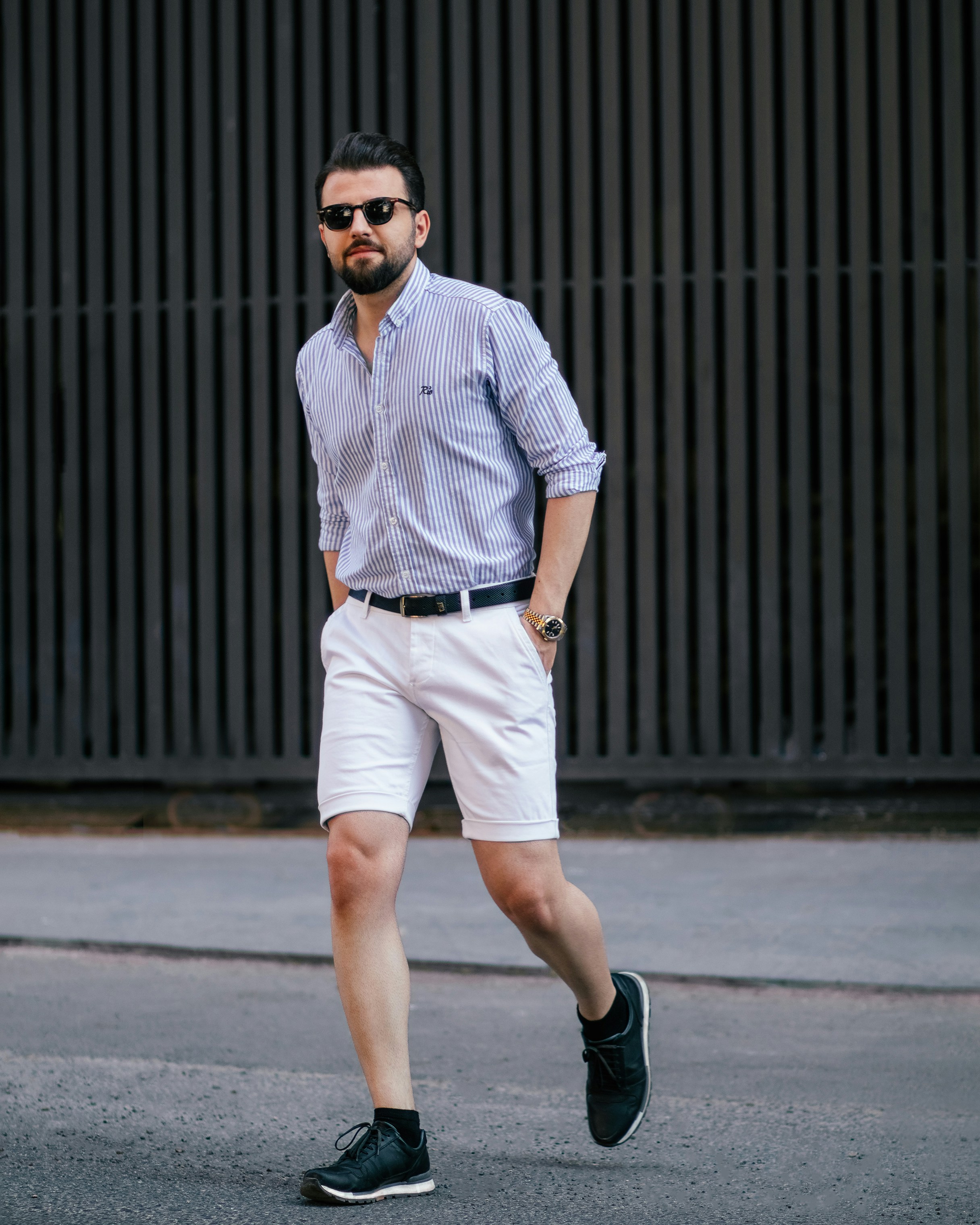 a man walking down the street in shorts