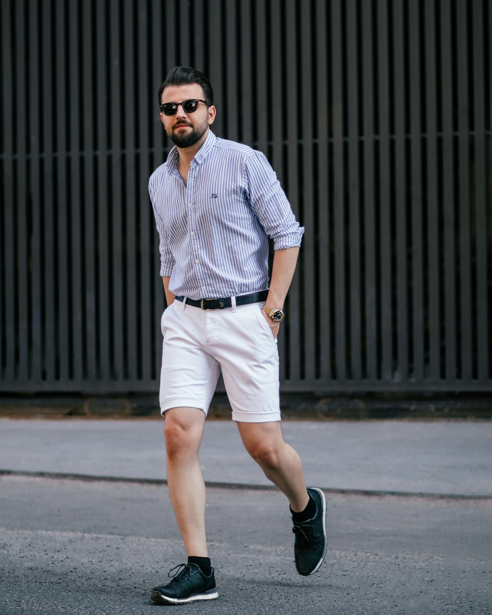 a man walking down the street in shorts