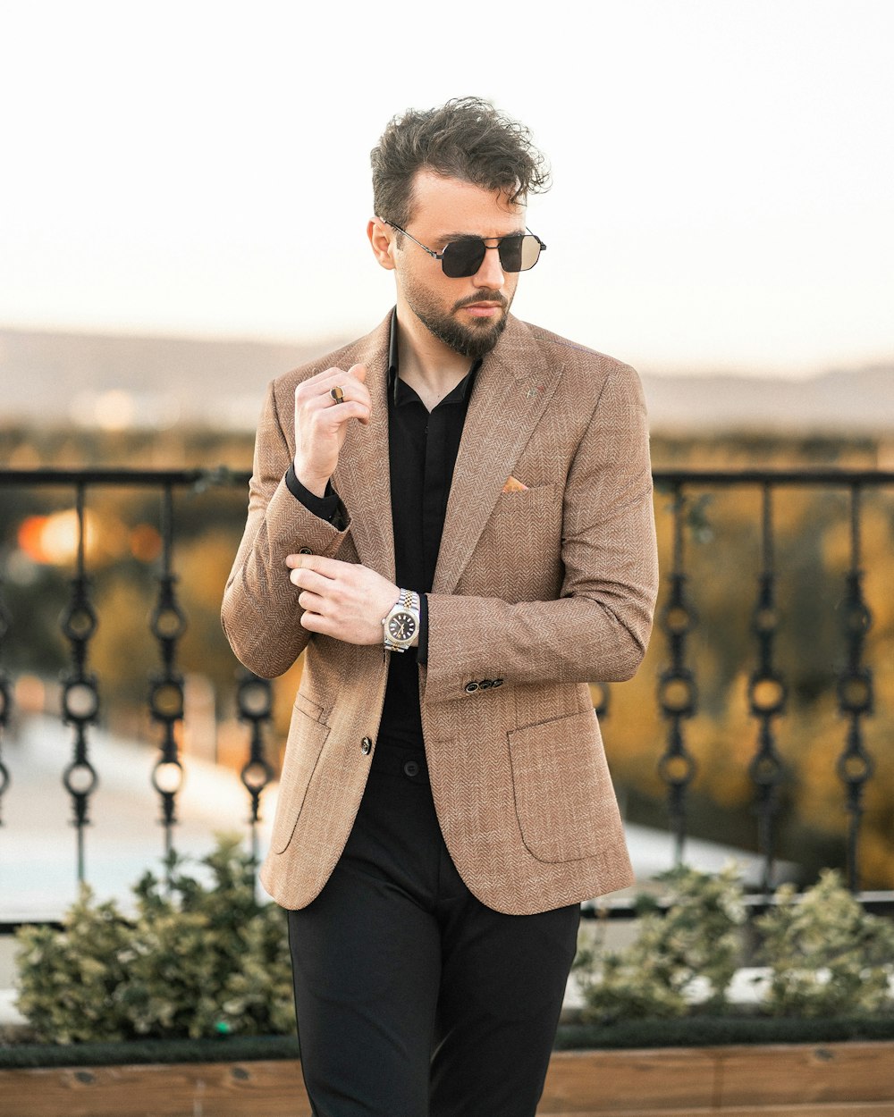 a man in a tan jacket and black shirt