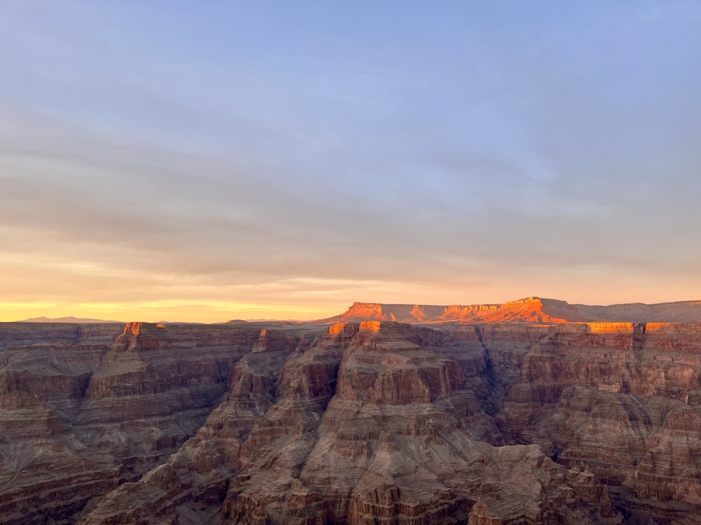 the sun is setting at the edge of the grand canyon