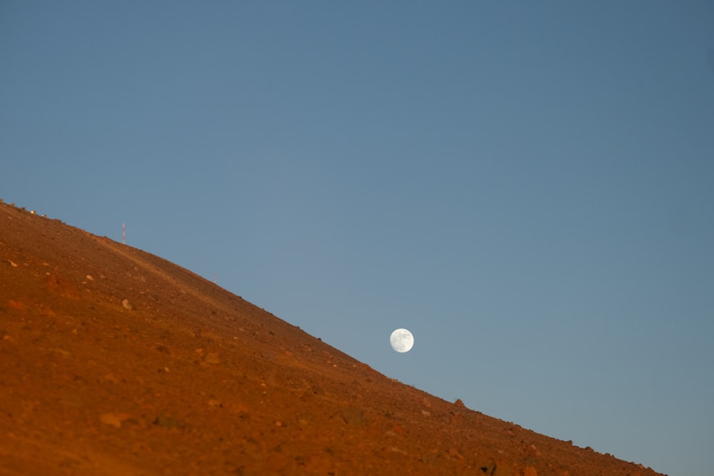 a view of the moon from the top of a hill