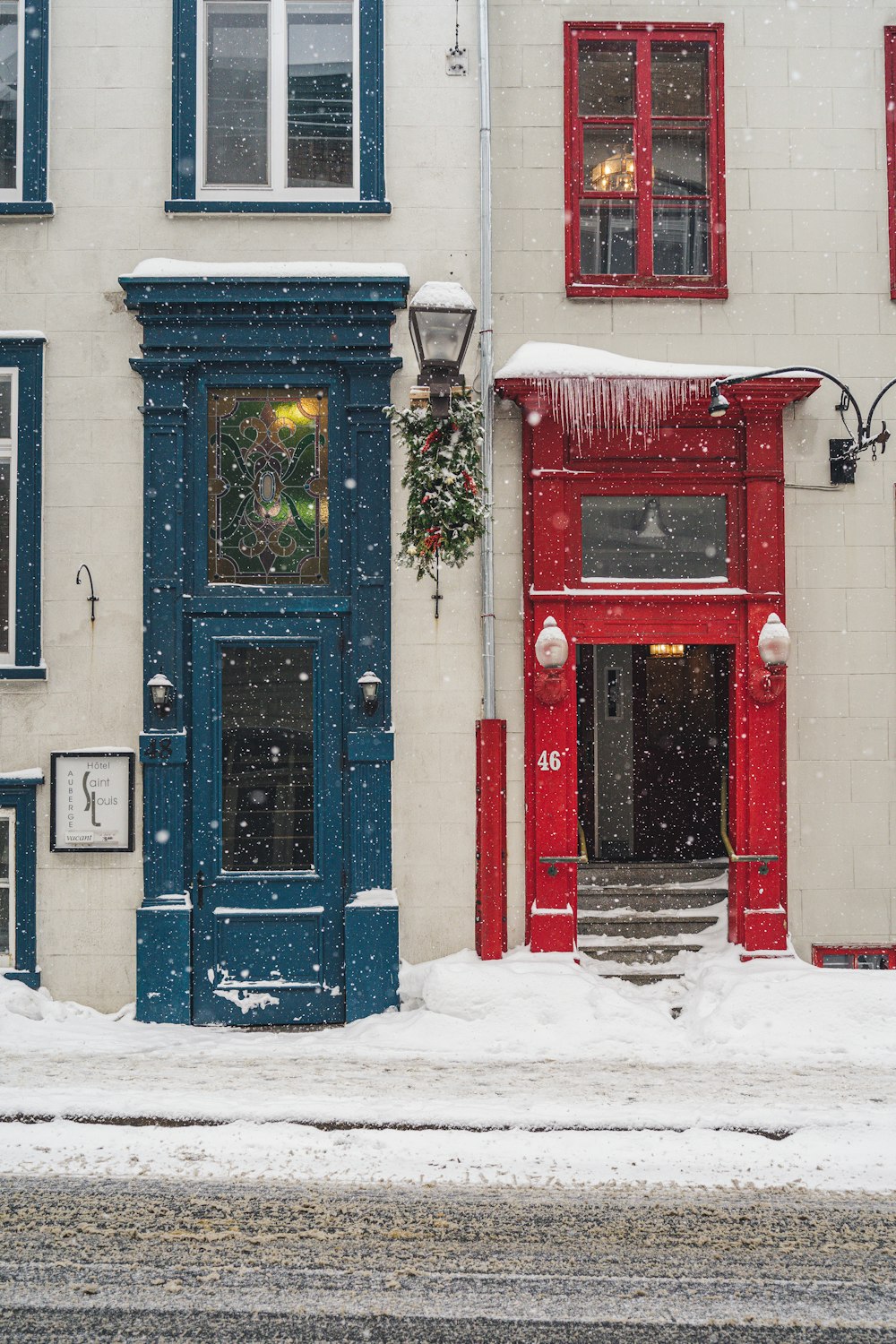 ein rot-blaues Gebäude mit einer blauen Tür im Schnee