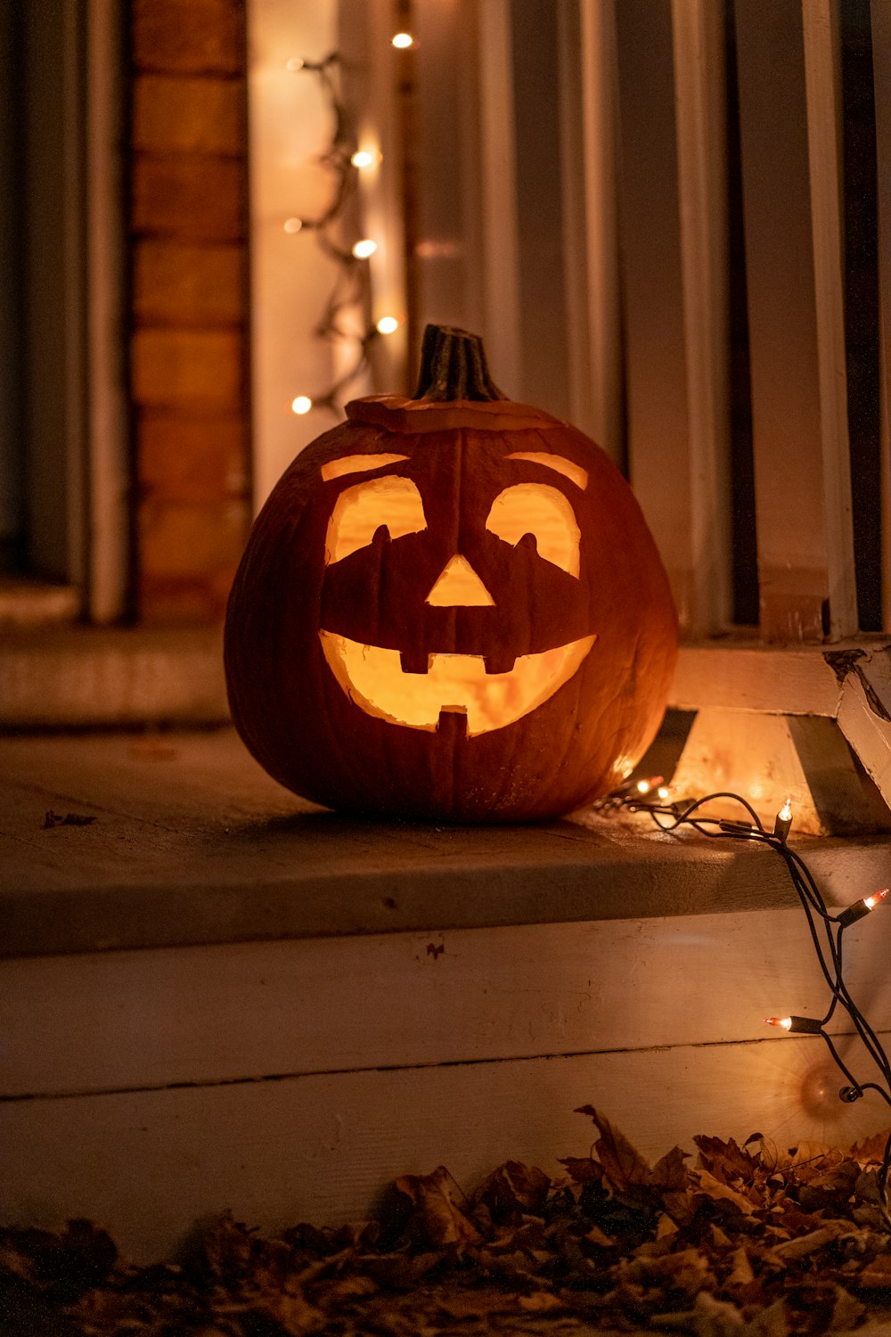 a carved pumpkin sitting on the steps of a house