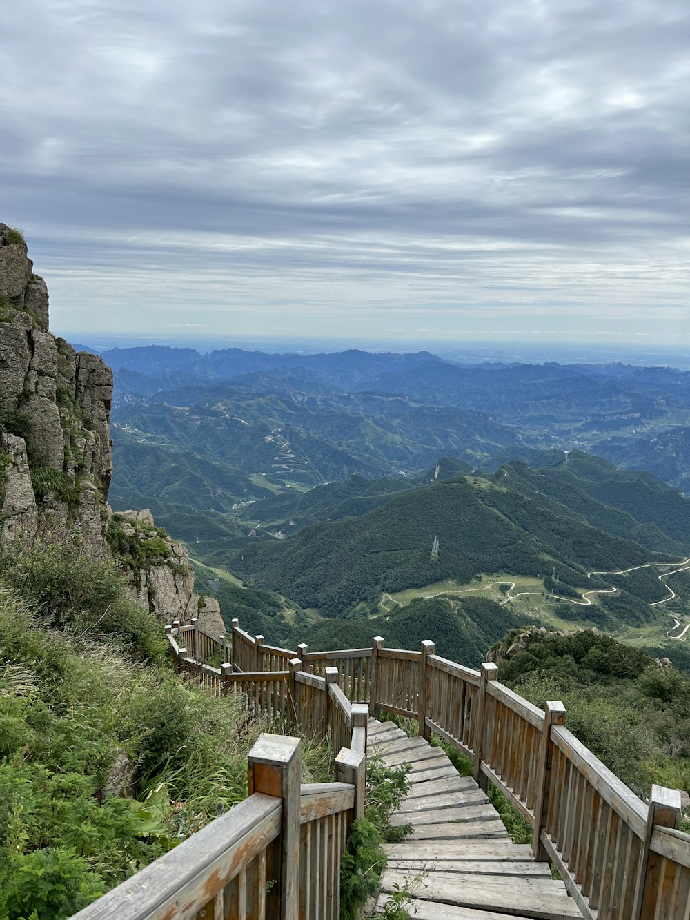 a wooden staircase leading to a scenic view of mountains