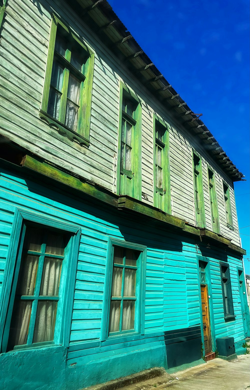 a blue building with green shutters and windows