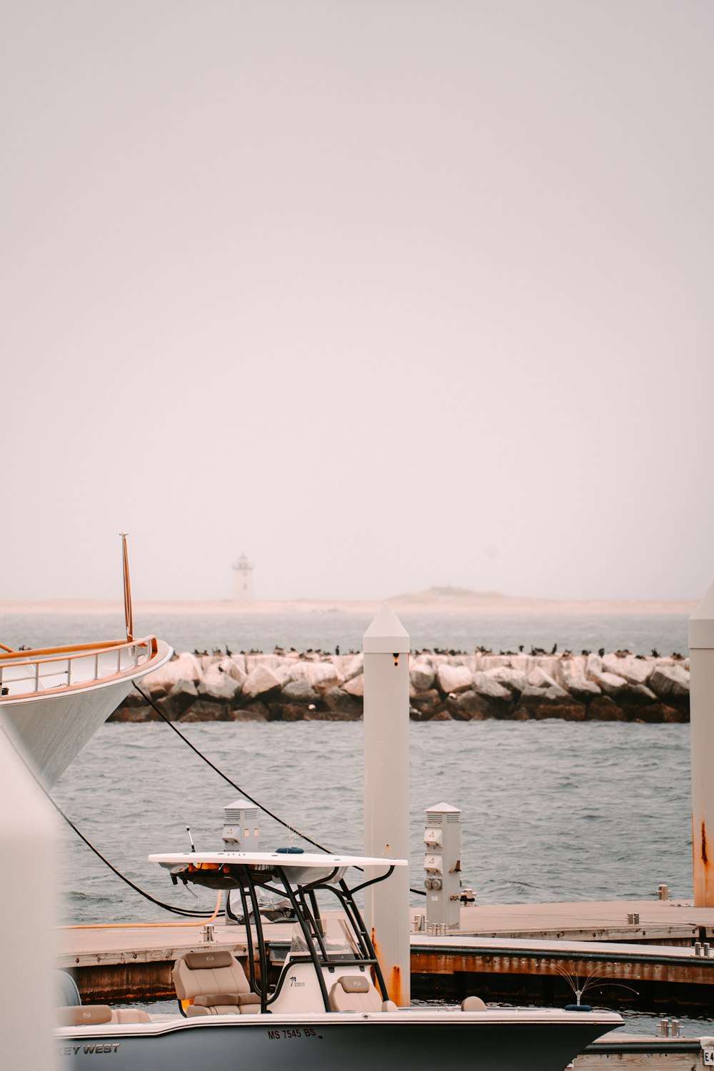 Ein Boot, das an einem Pier angedockt ist, mit einem Boot im Hintergrund