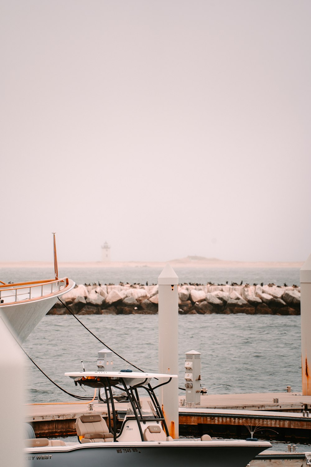 a boat docked at a pier with a boat in the background