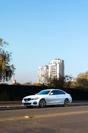A sleek white sedan parked on a sunny street in Anantapur.