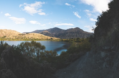 A tranquil lake surrounded by lush greenery and mountains.