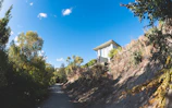 A panoramic view of a modern villa surrounded by lush greenery under a clear blue sky.
