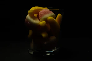 Colorful, chilled gummy snacks for pets in a glass bowl, glistening under soft light.