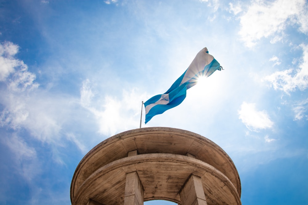 a blue and white flag on top of a tower