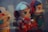 Three vinyl toy figures with oversized heads and exaggerated eyes. The central figure is dressed in a space suit, holding a red canister with a Coca-Cola logo. The figure on the right wears a green outfit with a red and black helmet. The figure on the left is partially visible with a smiling expression.