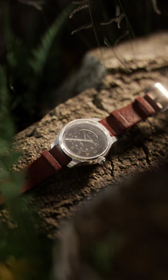 A green men's watch placed casually on a denim jacket sleeve.