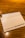 A wooden table surface with a white napkin featuring the Starbucks logo and text indicating the company's focus on sourcing and roasting coffee since 1971.