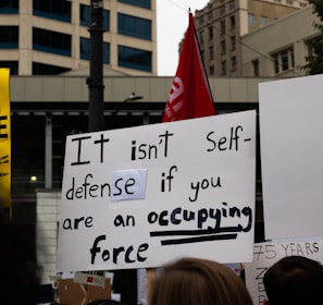 a group of people holding signs in front of a building