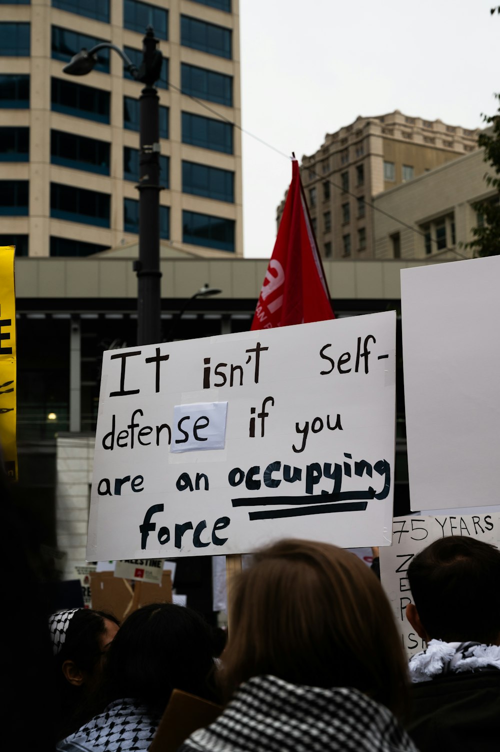 a group of people holding signs in front of a building