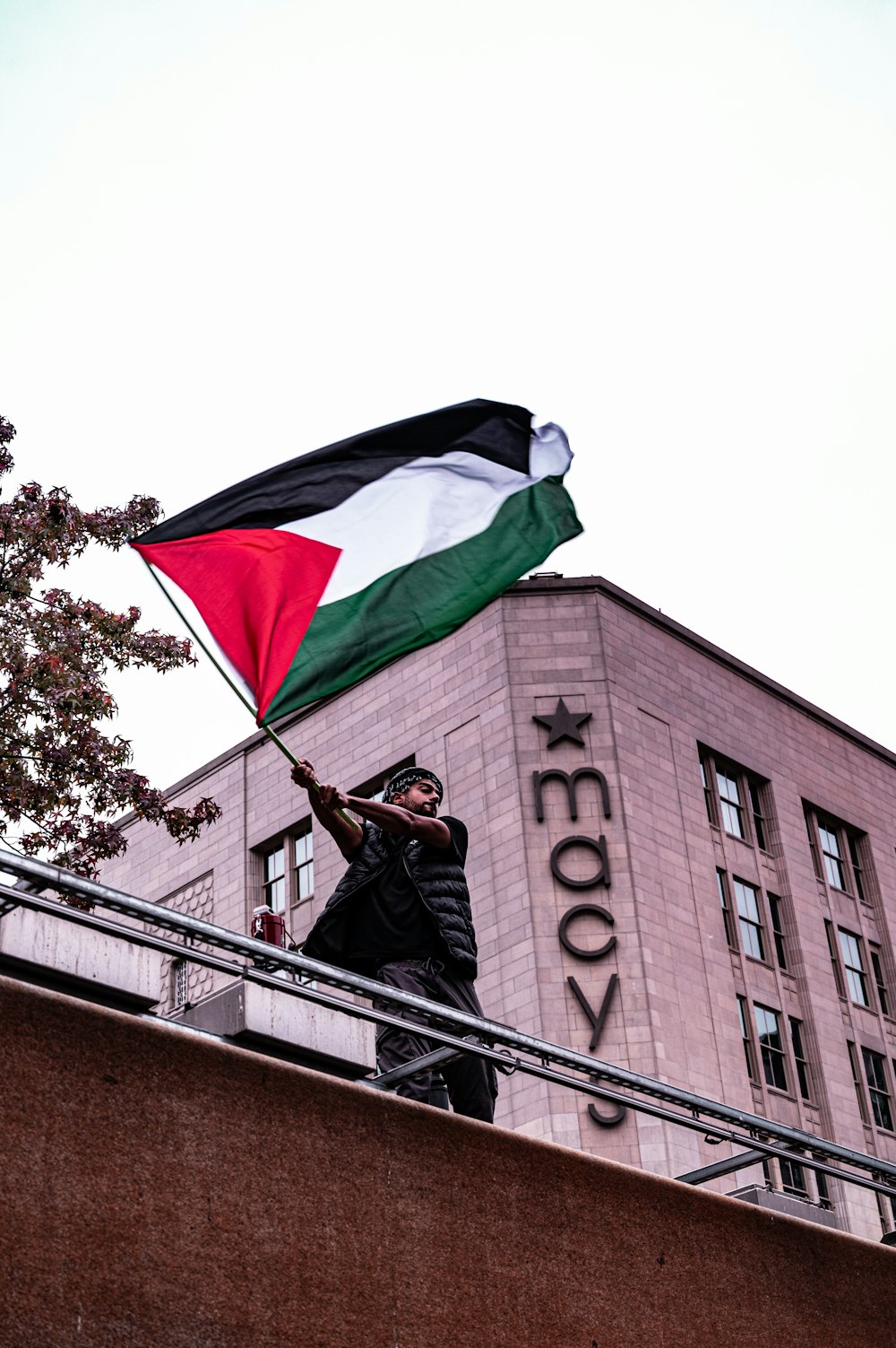 a man holding a flag on top of a building