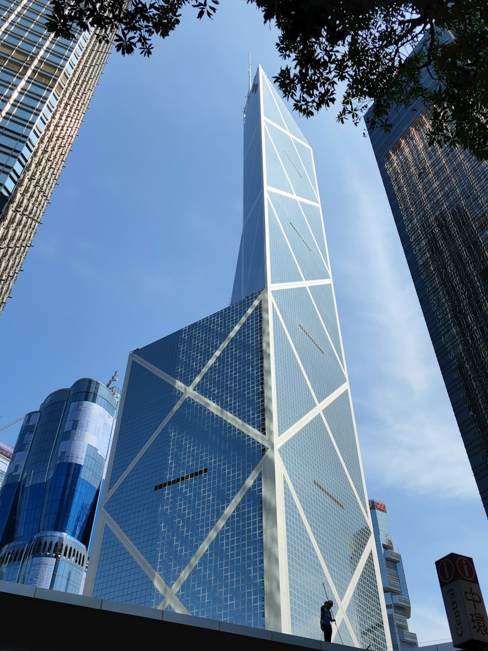 a tall skyscraper with a man standing in front of it