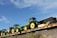 Yellow heavy machinery being loaded onto a flatbed truck with a clear blue sky background.