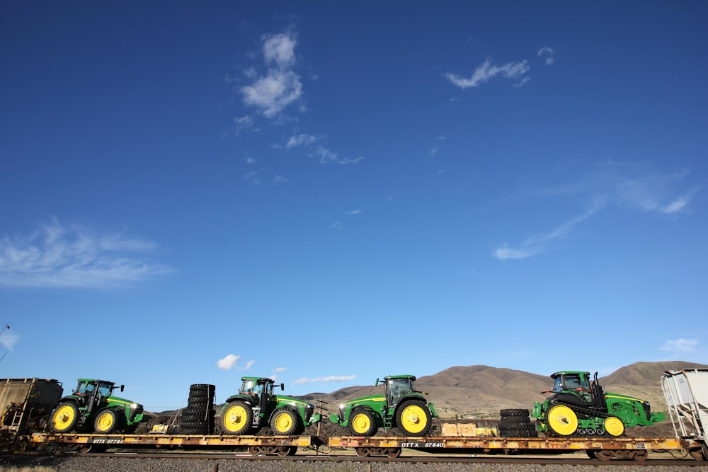 a row of tractors sitting on top of a train track