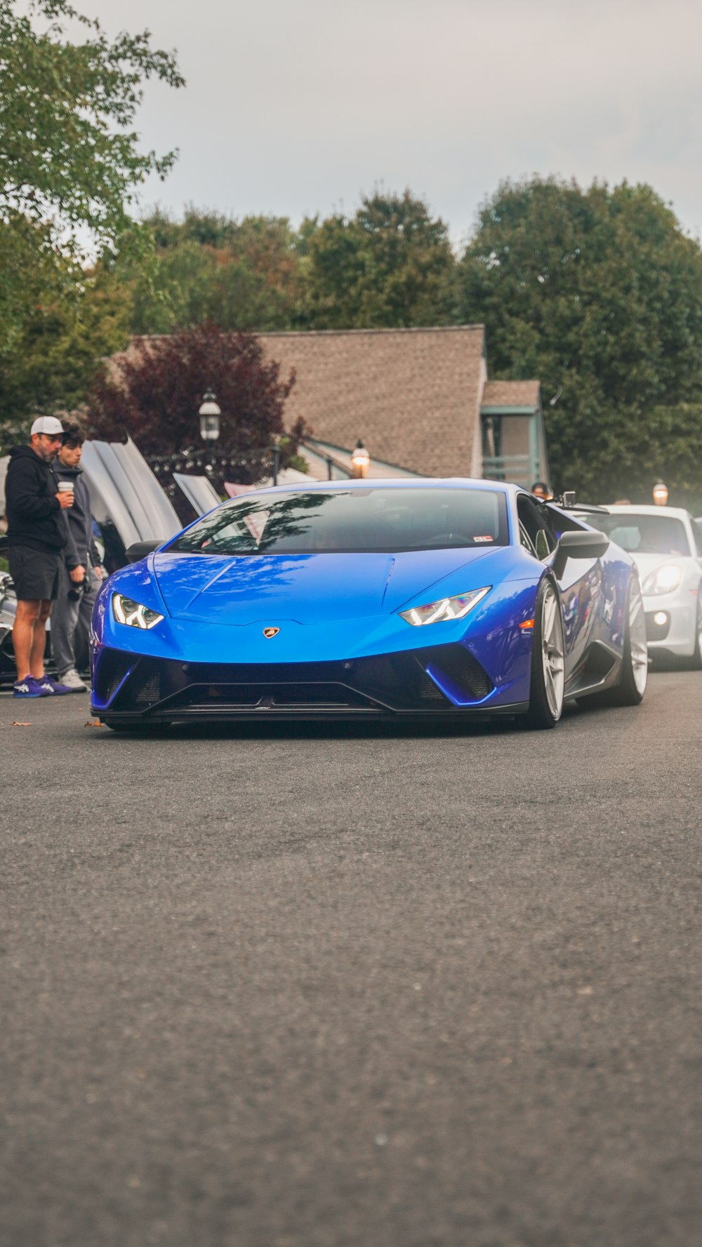 a blue sports car driving down a street next to other cars