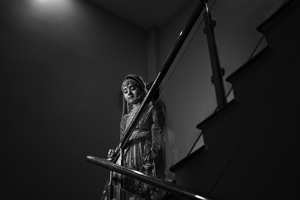 a black and white photo of a woman on a staircase