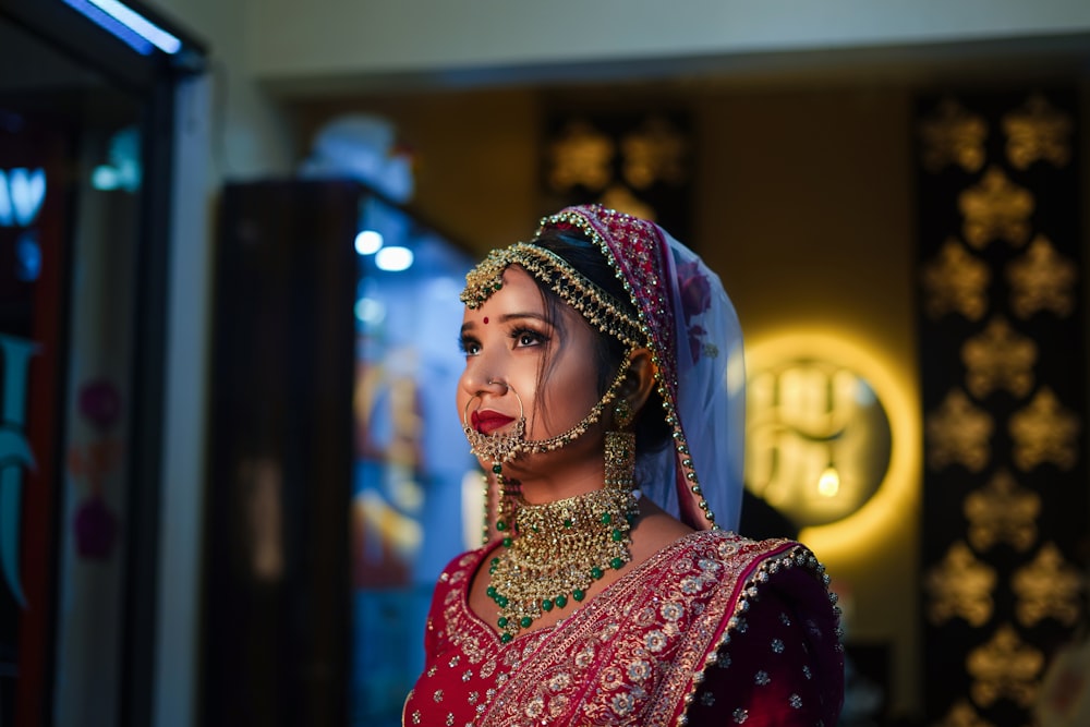 a woman in a red and gold bridal outfit