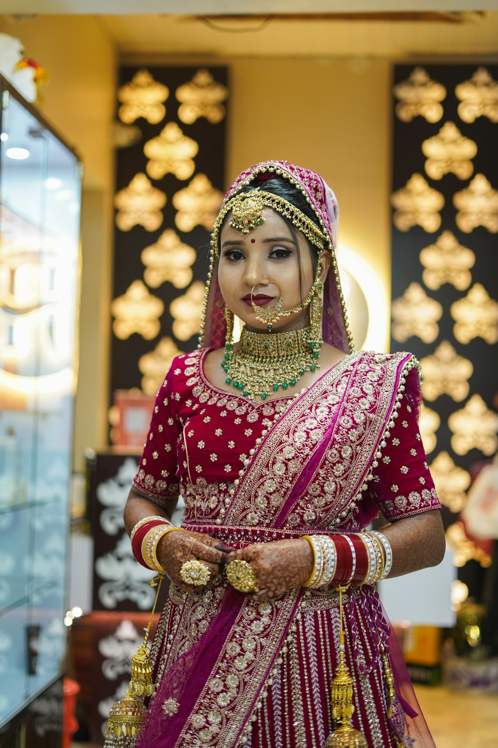 a woman in a red and gold bridal outfit