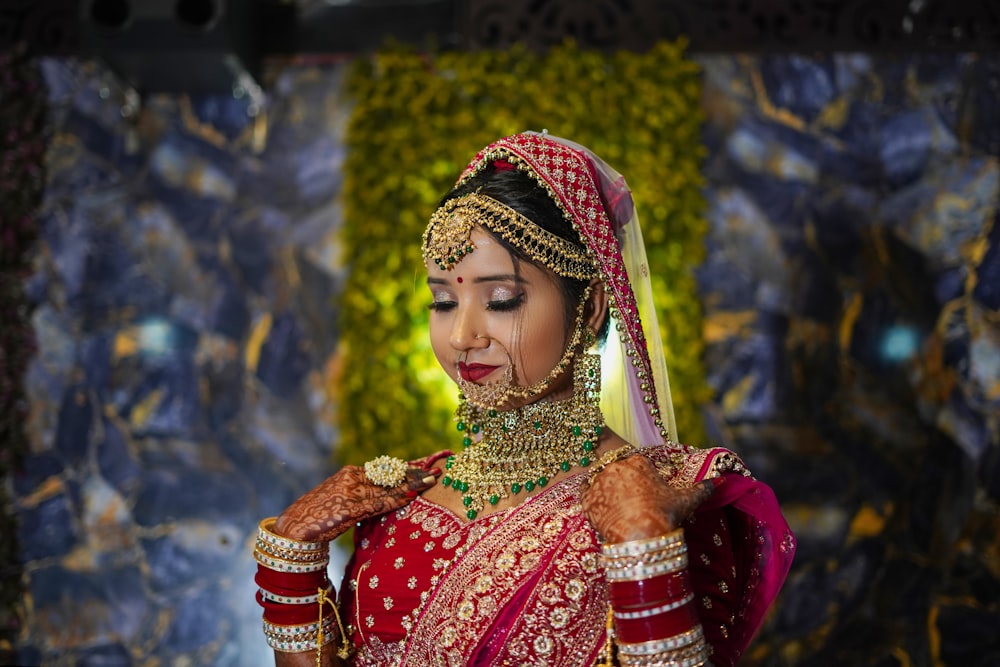 a woman in a red and gold bridal outfit