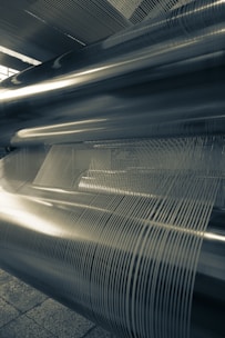 Close-up of shiny galvanized steel coils reflecting light in a factory setting