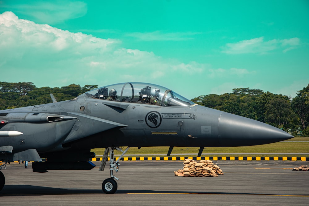 a fighter jet sitting on top of an airport runway