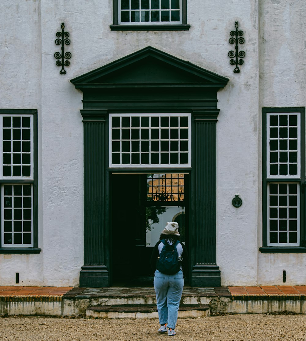 a person standing in front of a white building
